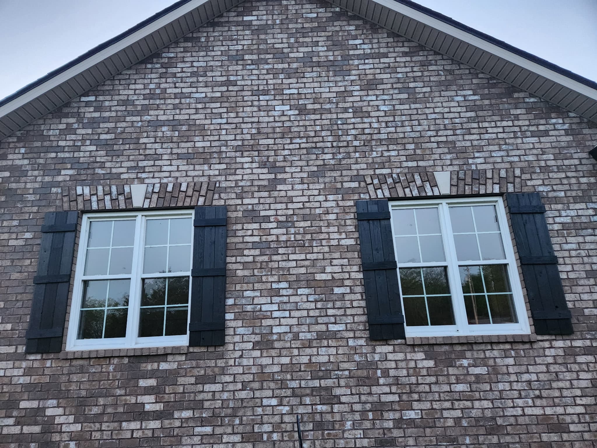 Gable end with two windows, both with black cedar shutters
