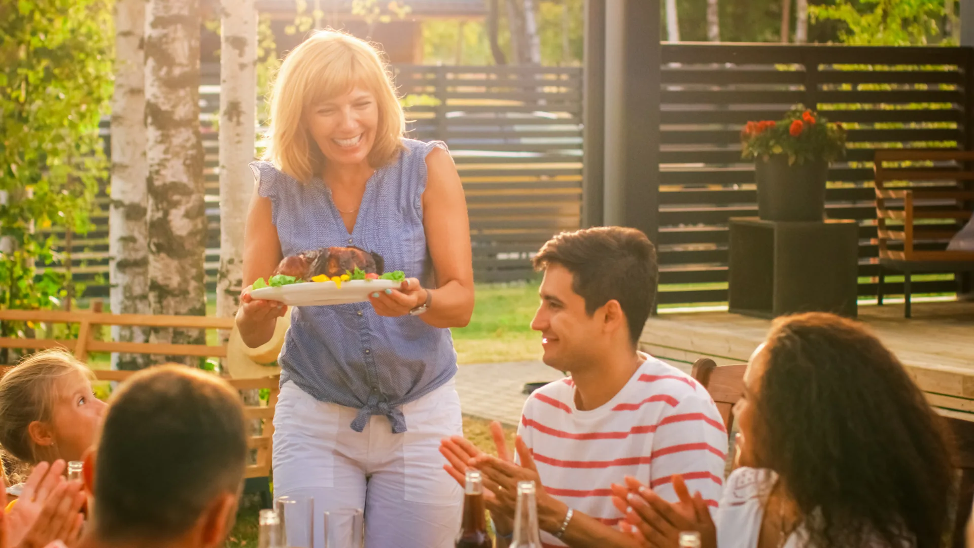 Family sharing a meal on their stained deck