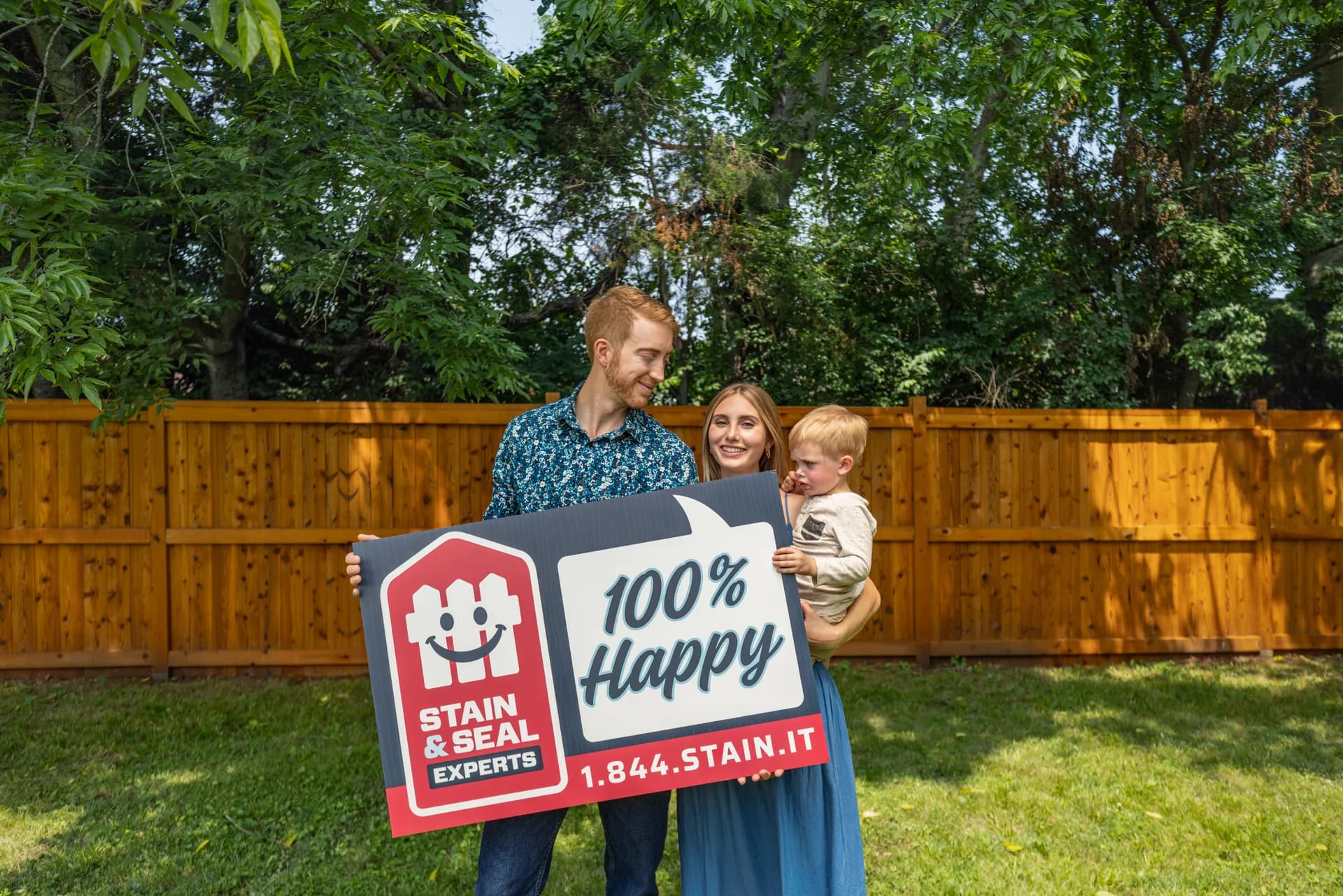 Happy family with their freshly stained fence