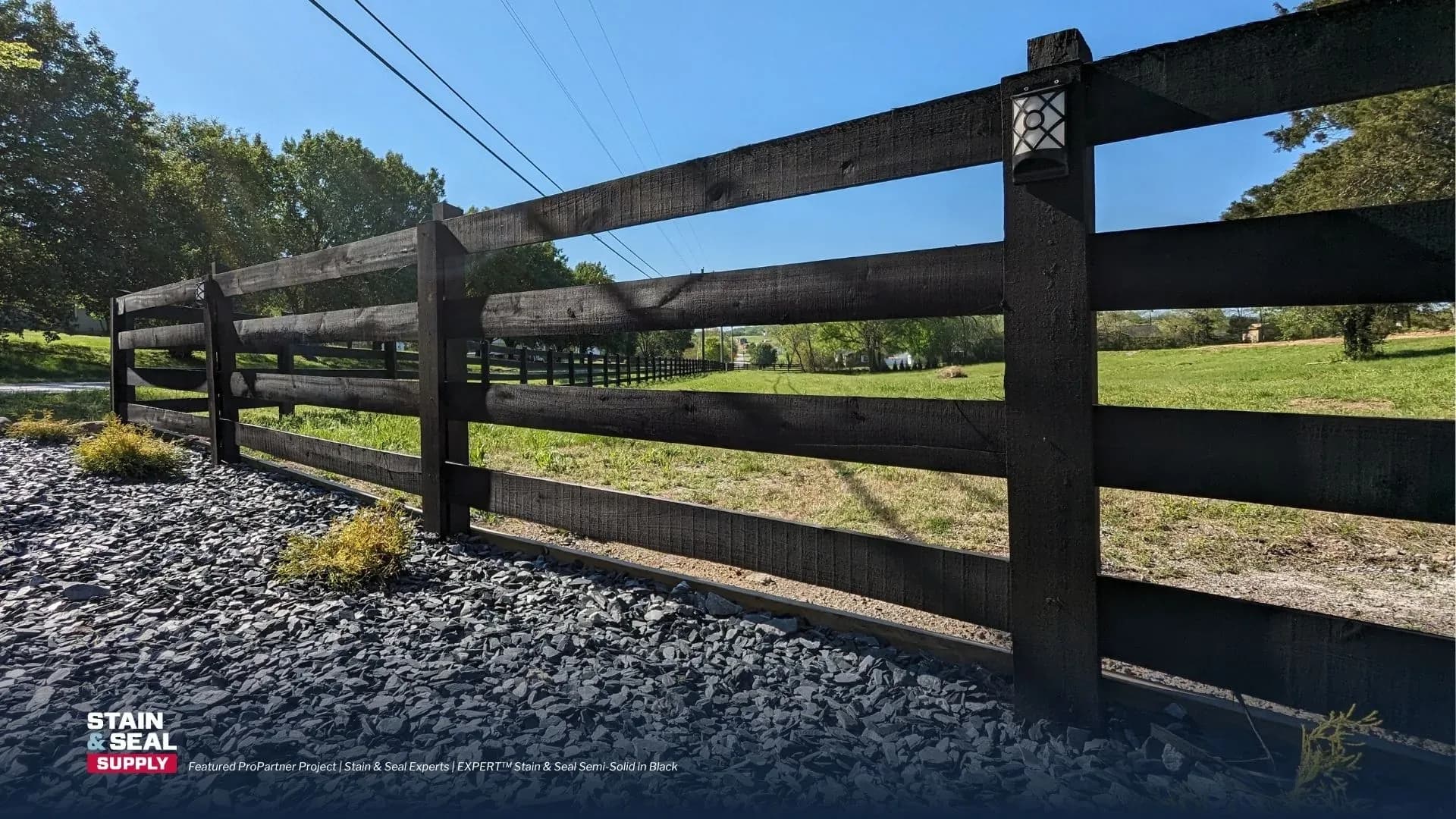 Stained black ranch fence
