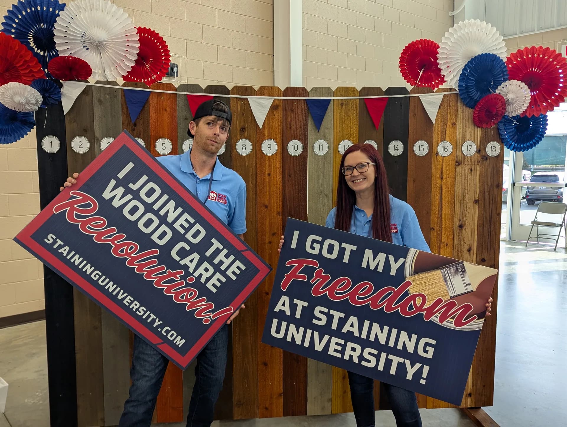 Attendees holding I joined the wood care revolution and I got my freedom at Staining University signs
